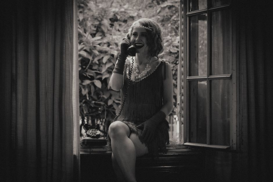 窓辺で電話をしている女性