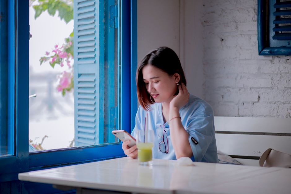 窓辺で電話をしている女性