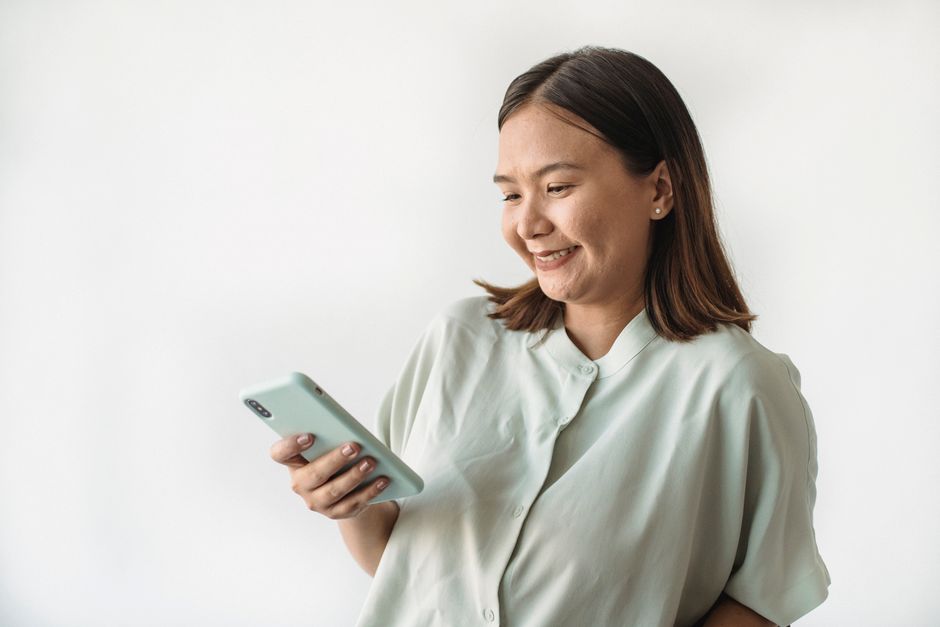 スマートフォンを見て嬉しそうに微笑む女性