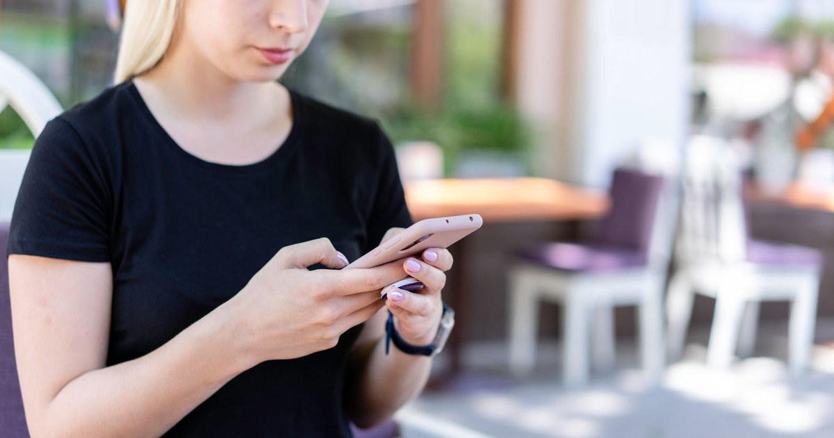 スマホを手に片思いの相手からの連絡を待つ女性