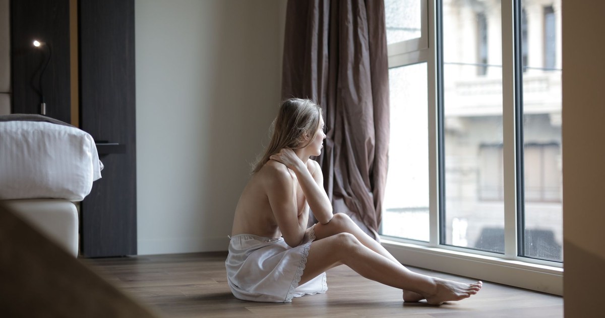 窓辺で一人考え込む女性、既婚者への片思いのイメージ