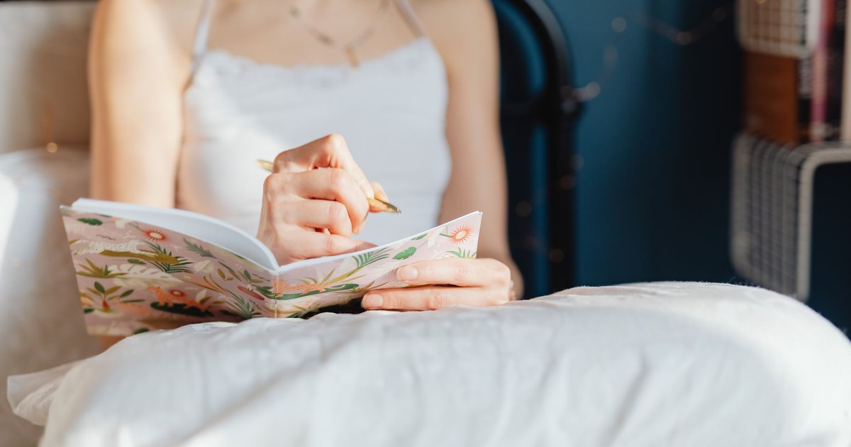 朝の光の中でノートに書き出す女性、気持ちの整理