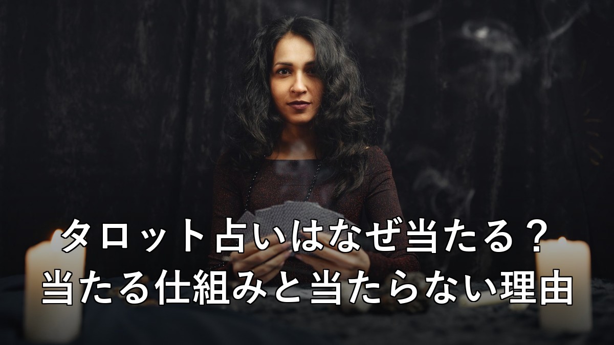 暗闇の中でろうそくとタロットカードを持つ占い師のイメージ