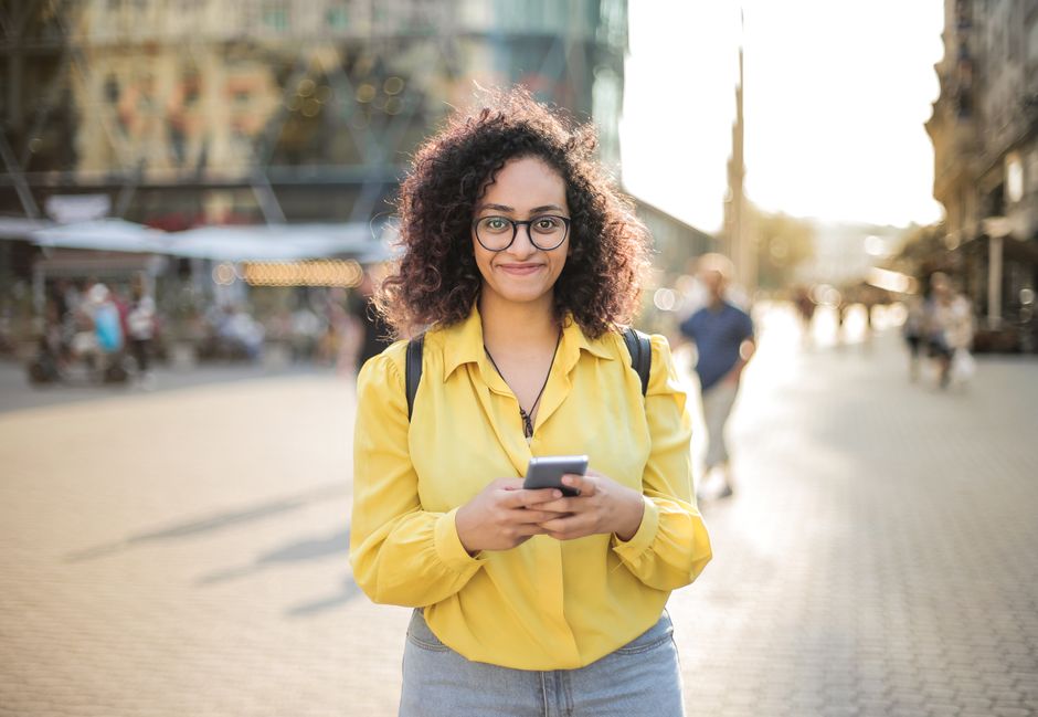 スマートフォンを見つめながら微笑む女性