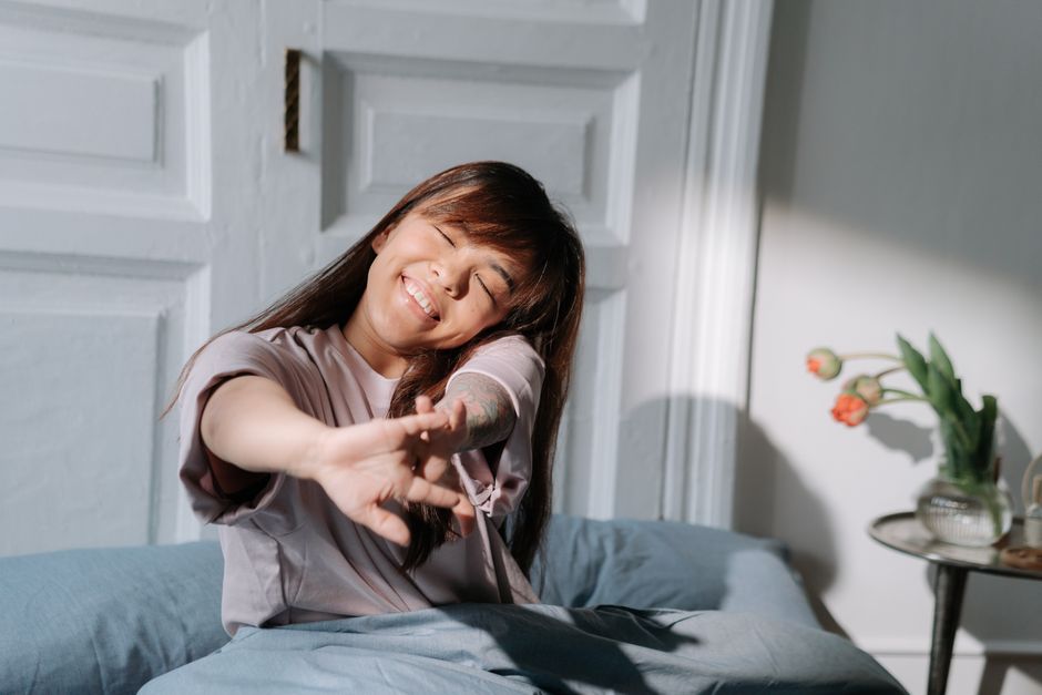 朝のびをする女性