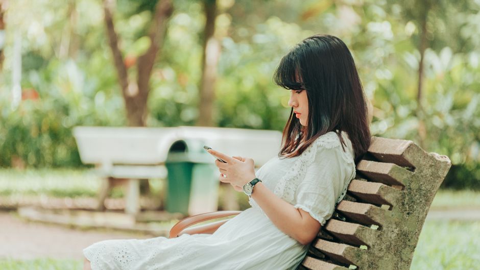 スマートフォンを見つめながら物思いにふける女性