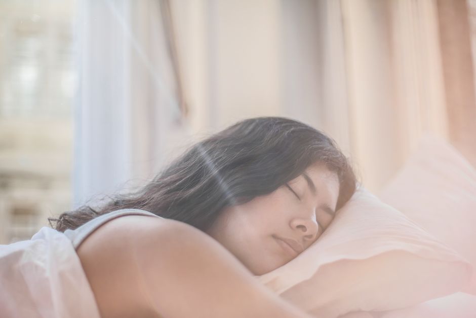 朝の光のなかで目覚める女性
